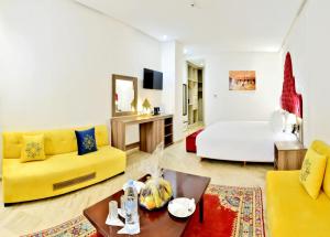 Fes Heritage Boutique luxury Hotel في فاس: غرفة معيشة مع أريكة صفراء وسرير