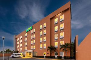 a hotel with a car parked in front of it at City Express Junior by Marriott Veracruz Aeropuerto in Veracruz