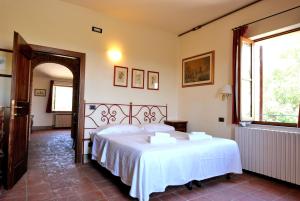 a bedroom with a large white bed in a room at I Casali Della Ghisleria in Ospedalicchio