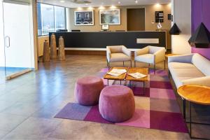 a lobby with couches and chairs and a table at City Express by Marriott Leon in León