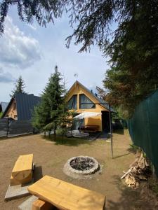 een achtertuin met een tent en een vuurplaats bij Domki AS in Radawa