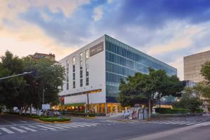 un gran edificio en una calle de la ciudad con un paso de peatones en City Express Plus by Marriott Insurgentes Sur, en Ciudad de México