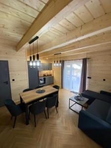 ein Esszimmer und ein Wohnzimmer mit einem Tisch und Stühlen in der Unterkunft Domki AS in Radawa
