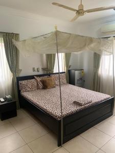 a bedroom with a bed with a canopy at Sandpark Place, West Hills in Accra