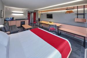 a hotel room with a large bed and a kitchen at City Express by Marriott Tampico in Tampico