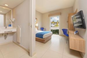 um quarto de hotel com uma cama e uma televisão em City Express by Marriott San José Costa Rica em San José
