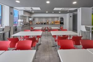 a restaurant with white tables and red chairs at City Express Junior by Marriott Juarez Consulado in Ciudad Juárez