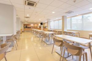 a dining room with tables and chairs in a cafeteria at City Express by Marriott San José Costa Rica in San José