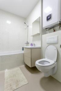 a white bathroom with a toilet and a sink at Apartament Perla Falezei in Galaţi +16 photos