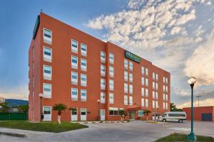 un edificio rojo con una furgoneta estacionada frente a él en City Express Junior by Marriott Tuxtla Gutierrez Poliforum, en Tuxtla Gutiérrez