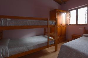 1 dormitorio con 2 literas y ventana en Apartamentos El Campal en Felechosa