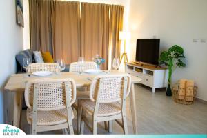 a dining room with a table and chairs and a television at Deluxe Condo/1BR-1BT/Close to Beach/Pool View in Punta Cana