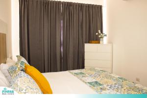 a bedroom with a bed and a window with curtains at Deluxe Condo/1BR-1BT/Close to Beach/Pool View in Punta Cana