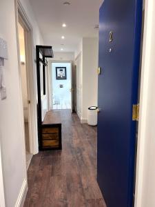 a hallway with a blue door leading to a bathroom at Sophia's Cwtch in Cardiff