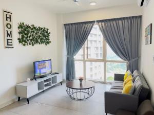 sala de estar con sofá, mesa y TV en AFINITI-Legoland-walk5min CottonSheep 2RB Max8pax Bathtub en Nusajaya