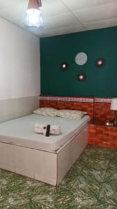 a bed in a room with a green wall at hotel marsella in Sonsonate