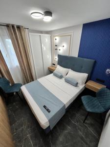 1 Schlafzimmer mit einem Bett und 2 Stühlen in der Unterkunft Elegante Apartamento TRES COLORES in Alicante