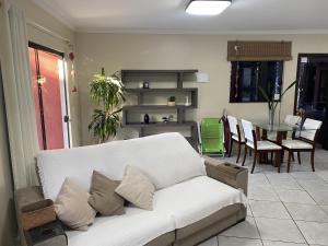 sala de estar con sofá blanco y mesa en Pousada Praia dos Ingleses, en Florianópolis