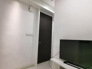 a living room with a television and a black door at Strait Garden Family Suites by Maj in Jelutong