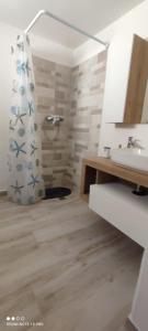bagno con doccia, lavandino e specchio di Casa Rosina a Castrignano del Capo