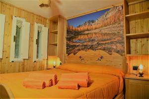 um quarto com duas camas e um quadro na parede em I Larici - Appartamento per sognare em Alpe Devero