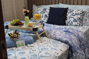 a bed with a tray of fruit and a drink on it at Makambira Residence no Centro de Porto de GalinhaS in Porto De Galinhas +80 photos