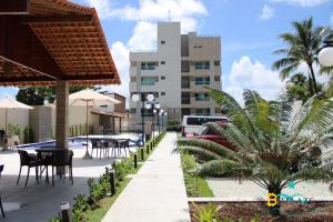 a patio with tables and chairs and a building at Makambira Residence no Centro de Porto de GalinhaS in Porto De Galinhas
