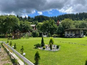 une cour avec une aire de jeux et une maison dans l'établissement SOKIL HOUSE, à Slavsko