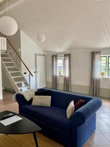 a living room with a blue couch and stairs at Kalkugnsvägen in Kolmården