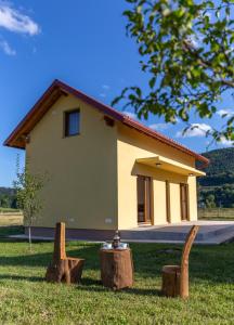 una pequeña casa con un montón de troncos delante de ella en Kuća za odmor Trota, en Otočac
