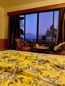 ein Schlafzimmer mit einem Bett mit gelber Decke in der Unterkunft Rock City Resort in Mingora