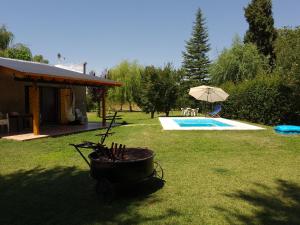 un cortile con piscina e una casa di Mágico Atardecer Cabaña a Tunuyán