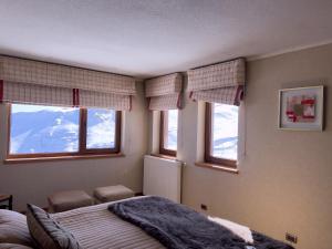 a bedroom with a bed and two windows with mountains at Ski-in/out. Amplio y cómodo Departamento in Lo Barnechea