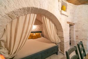 阿爾貝羅貝洛的住宿－Trullo Arboris，卧室配有砖墙内的床铺