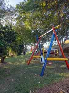 uma fila de balanços coloridos em um parque em Pousada e Pesque e Pague Vista Alegre em Paty do Alferes