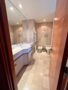 a bathroom with two sinks and a toilet at Ski-in/out. Amplio y cómodo Departamento in Lo Barnechea