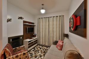 sala de estar con sofá y TV en Apartamento de 1 quarto, en Gramado