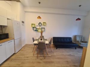 a living room with a table and a blue couch at Central EvaApartments One in Bacău