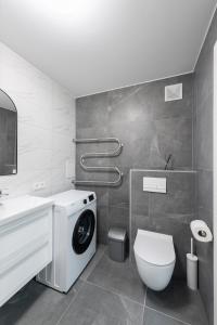 a bathroom with a washing machine and a toilet at Stiklo Apartamentai in Radviliškis