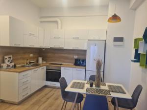 a kitchen with a table and chairs and a refrigerator at Central EvaApartments One in Bacău +4 photos