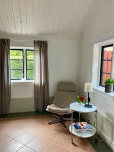 um quarto com uma cadeira, uma mesa e janelas em Kalkugnsvägen em Kolmården