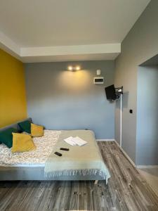 ein Schlafzimmer mit einem Bett mit gelben Kissen in der Unterkunft Apartament Kościuszko in Kattowitz