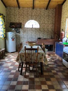a kitchen with a table and chairs and a refrigerator at Casa do Alecrim in São Roque de Minas
