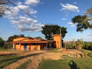 uma casa com um parque infantil em frente em Casa do Alecrim em São Roque de Minas