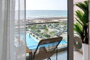 a balcony with a view of a pool and the ocean at TGM Sunrise View in Infinity Pool & Spa Resort in Mamaia Sat/Năvodari