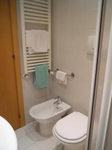 bagno bianco con servizi igienici e lavandino di Albergo Italia a Urbino