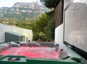 una bañera llena de agua rosa con una montaña en Barceló Apartaments, en Monistrol