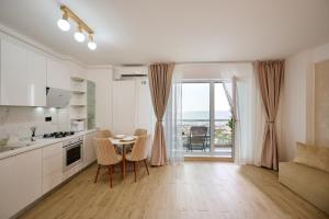 a kitchen and dining room with a table and chairs at TGM Sunrise View in Infinity Pool & Spa Resort in Mamaia Sat/Năvodari +54 photos