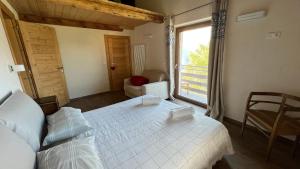 sypialnia z białym łóżkiem i oknem w obiekcie Les Flocons Pila w mieście Pila