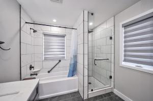 a bathroom with a tub and a glass shower stall at Lake view cottage with three ensuites and elevator in Fort Erie